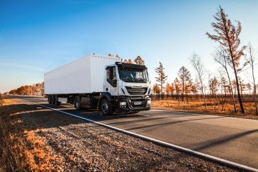 Autonóm képességekkel felszerelt Iveco teherautó közlekedik országúti környezetben.