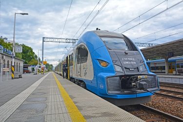 Korszerű motorvonat érkezik egy regionális vasútállomás peronjára.