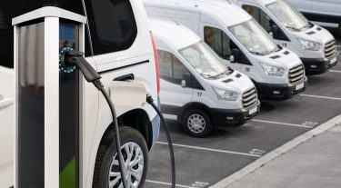 Töltés alatt álló elektromos furgonok egy vállalati flottában.