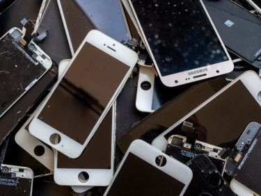 Lecserélt és sérült mobiltelefonok egymásra halmozva, újrahasznosításra várva.