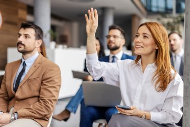 Szakmai képzésen részt vevő hallgatók láthatók, miközben egy résztvevő kérdésre jelentkezik.